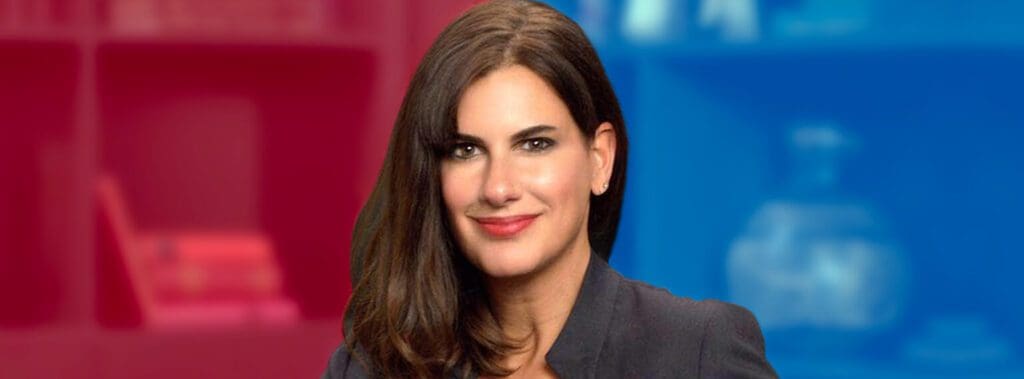 Professional woman with dark hair smiling confidently against a blurred background.