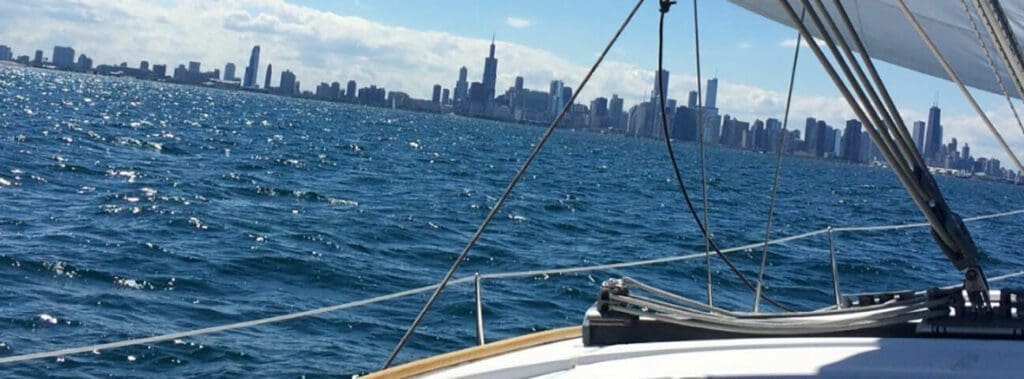 View of a city skyline from a sailboat on the water.